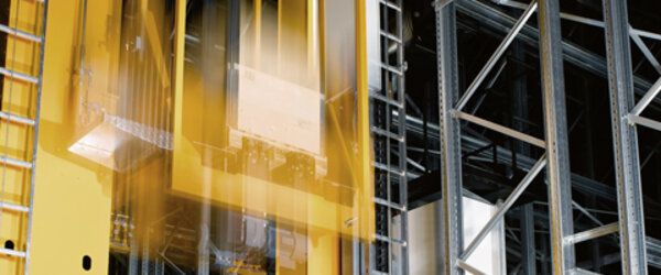 Lifting carriage of the stacker crane moves downwards Lifting carriage of the stacker crane moves downwards