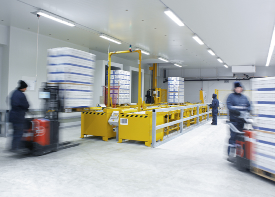 Bischof employees in cold protection suits manually load the conveyor system with the forklift truck